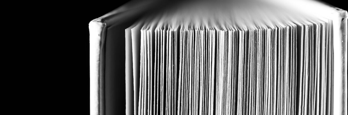 Monochrome image, opened hard covered book pages close up macro shot with space for text.